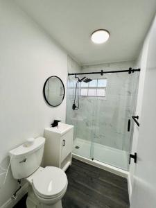 y baño blanco con aseo y ducha. en Stylish 3/2 centrally located!, en Miami