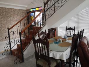 a dining room with a table and a staircase at Chachagüi in Pasto