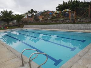 a large blue swimming pool with a playground in the background at Chachagüi in Pasto