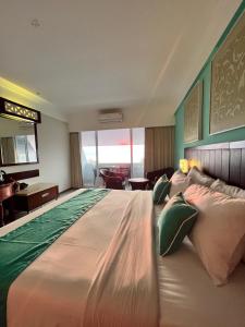 a large bed in a hotel room with a large bed at Kuta One Party Hotel in Kuta