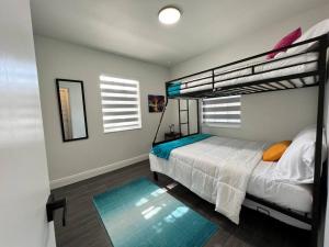 1 dormitorio con 2 literas y alfombra azul en Stylish 2/1 centrally located!, en Miami