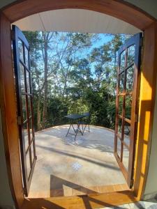 una porta aperta su un patio con tavolo all'aperto di Casinha acolhedora da mata - Rota do Vinho a São Roque