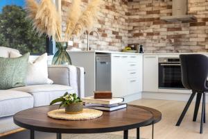 a living room with a coffee table and a kitchen at Onetangi Beach Stays Apartment - Coast & Country in Onetangi