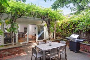 a patio with a table and chairs and a grill at Boutique Stays - Alkira House in Melbourne +11 photos