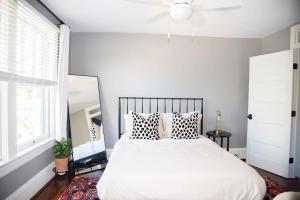 um quarto com uma cama branca com almofadas e uma ventoinha de tecto em The Winona House - Boutique Hotel Near Downtown em Roanoke