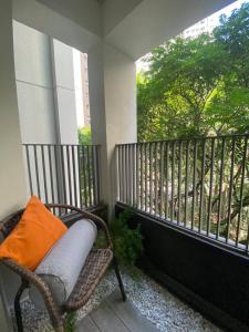 uma cadeira de vime com uma almofada laranja sentada numa varanda em Apartamento em São Paulo (Rosabianco) em São Paulo