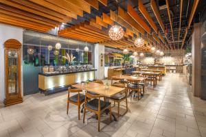un ristorante con tavoli e sedie e un bar di 1O1 URBAN Jakarta Pemuda a Giacarta