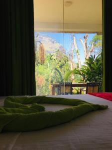 a green bed with a view of a tree at Green Mountain Villa in Ella