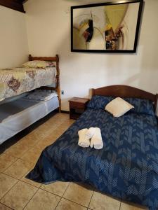 1 dormitorio con 1 cama y 2 toallas en Recanto do Pajé, en Praia do Rosa