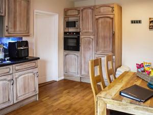 cocina con armarios de madera y mesa de madera en Old Toads Barn en Theddlethorpe Saint Helen