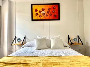 1 dormitorio con 1 cama con una pintura en la pared en Departamento Céntrico Tucumán 1A en San Miguel de Tucumán