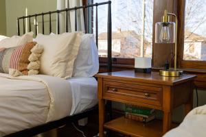 a bedroom with a bed and a table with a night stand at 4 Bedroom Suite At The Historic Winona House in Roanoke