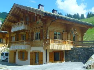 un gran edificio de madera con balcones. en Chalet Le Grand-Bornand, 7 pièces, 13 personnes - FR-1-467-31, en Le Grand-Bornand