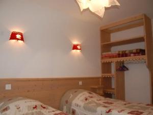 a bedroom with a bed and two lights on the wall at Appartement chalet pour 6 pers., animaux admis, parking - FR-1-467-39 in Le Grand-Bornand