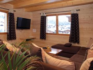 un salon avec un canapé et une télévision dans l'établissement Chalet familial, 5 chambres, hammam, cheminée, près des pistes - FR-1-467-44, au Grand-Bornand