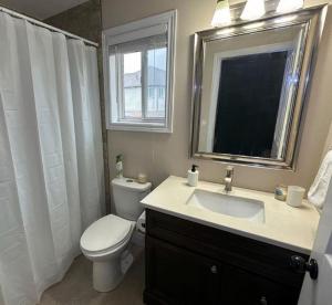 a bathroom with a toilet and a sink and a window at No available not in Welland