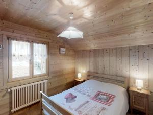 um quarto com uma cama num chalé de madeira em Appartement Le Grand-Bornand, 4 pièces, 6 personnes - FR-1-467-48 em Le Grand-Bornand