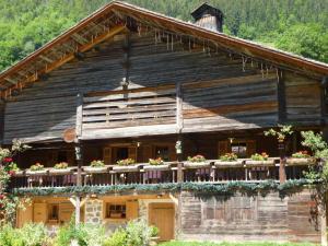 an old house with a balcony with flowers on it at Appartement Le Grand-Bornand, 4 pièces, 6 personnes - FR-1-467-87 in Le Grand-Bornand