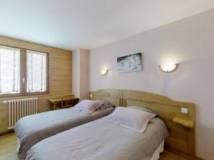 ein Schlafzimmer mit zwei Betten und einem Tisch und einem Fenster in der Unterkunft Appartement confortable 4 pers. proche pistes ski Le Grand-Bornand - FR-1-467-55 in Le Grand-Bornand