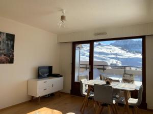 - un salon avec une table et une vue sur la montagne dans l'établissement Appartement Le Grand-Bornand, 1 pièce, 4 personnes - FR-1-467-91, au Grand-Bornand