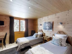 une chambre avec deux lits dans une cabane en rondins dans l'établissement Chalet spacieux pour 11 pers., proche pistes de ski, jardin, BBQ, équipements enfants - Le Grand-Bornand - FR-1-467-58, au Grand-Bornand