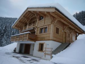 a log cabin with a deck in the snow at Chalet Le Grand-Bornand, 5 pièces, 10 personnes - FR-1-467-71 in Le Grand-Bornand