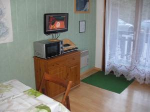 a room with a microwave and a television on a dresser at Appartement Le Grand-Bornand, 1 pièce, 4 personnes - FR-1-467-117 in Le Grand-Bornand