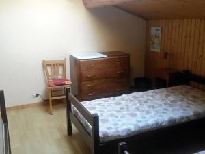 a bedroom with a bed and a dresser and a chair at Chalet Le Grand-Bornand, 7 pièces, 12 personnes - FR-1-467-121 in Le Grand-Bornand