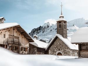 stary kościół ze śniegiem na dachu w obiekcie Studio cosy 4 pers. proche centre, balcon, parking privé, 700m pistes ski, navette gratuite - FR-1-467-118 w mieście Le Grand-Bornand