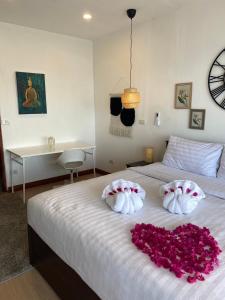 a bedroom with a white bed with pink flowers on it at New Appartement Fisherman in Bophut 