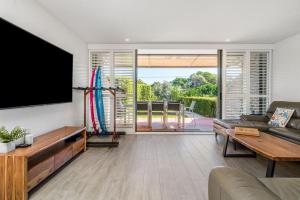 a living room with a tv and a couch at A Perfect Stay - 4 James Cook Apartments in Byron Bay