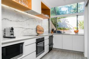 a kitchen with white countertops and a large window at A Perfect Stay - 4 James Cook Apartments in Byron Bay