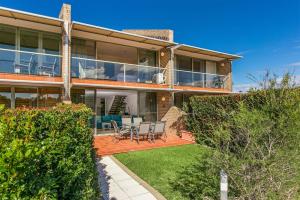 an image of a house with a patio at A Perfect Stay - 2 James Cook Apartments in Byron Bay