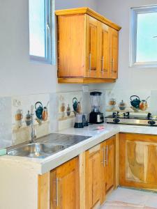 a kitchen with wooden cabinets and a sink at lake paradise in Habaraduwa