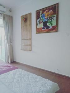 a bedroom with a bed and a picture on the wall at Trang Doan's homestay in Ấp Tân Bình (2)