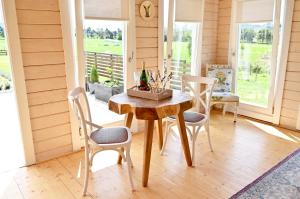 a dining room with a wooden table and chairs at Avocate' Cottage in Whiritoa