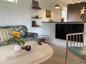 ein Wohnzimmer mit Tisch und Fernseher in der Unterkunft 4 person holiday home in Blokhus-By Traum in Blokhus