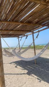 a hammock hanging from a wooden structure on a beach at Boca de agua Villas in Nautla