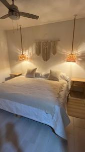 a bedroom with a large bed with two lights at Boca de agua Villas in Nautla