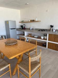 cocina con mesa de madera, sillas y encimera en Boca de agua Villas, en Nautla
