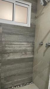 uma casa de banho com um chuveiro e uma parede de madeira em Boca de agua Villas em Nautla