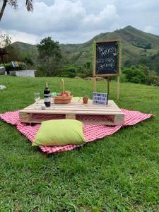 een picknicktafel met een bord en een krijtbord op het gras bij Kentia Eco Hotel Buga 