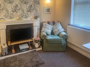 a living room with a chair and a television at Beckside Court in Brampton