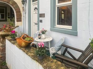 een patio met een tafel, stoelen en bloemen bij Beckside Court in Brampton