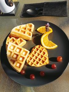 a plate of waffles with syrup and orange slices at VALLE LIFE in Sansoni