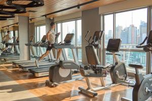 un grupo de personas corriendo en cintas de correr en un gimnasio en Queen Suite with City View at Acqua Private Residences en Manila