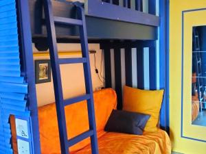 a bunk bed with a ladder and an orange couch at Studio Villard-de-Lans, 1 pièce, 5 personnes - FR-1-761-24 in Villard-de-Lans