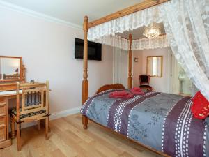 1 The Follys - Uk45189 في Abbotskerswell: غرفة نوم مع سرير المظلة ومكتب