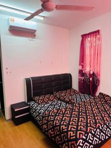een slaapkamer met een bed en een plafondventilator bij Tom’s Homestay in Batu-grotten