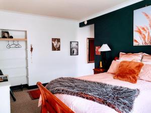 een slaapkamer met een bed met een groene accentmuur bij La Riviera Guesthouse in Riverton